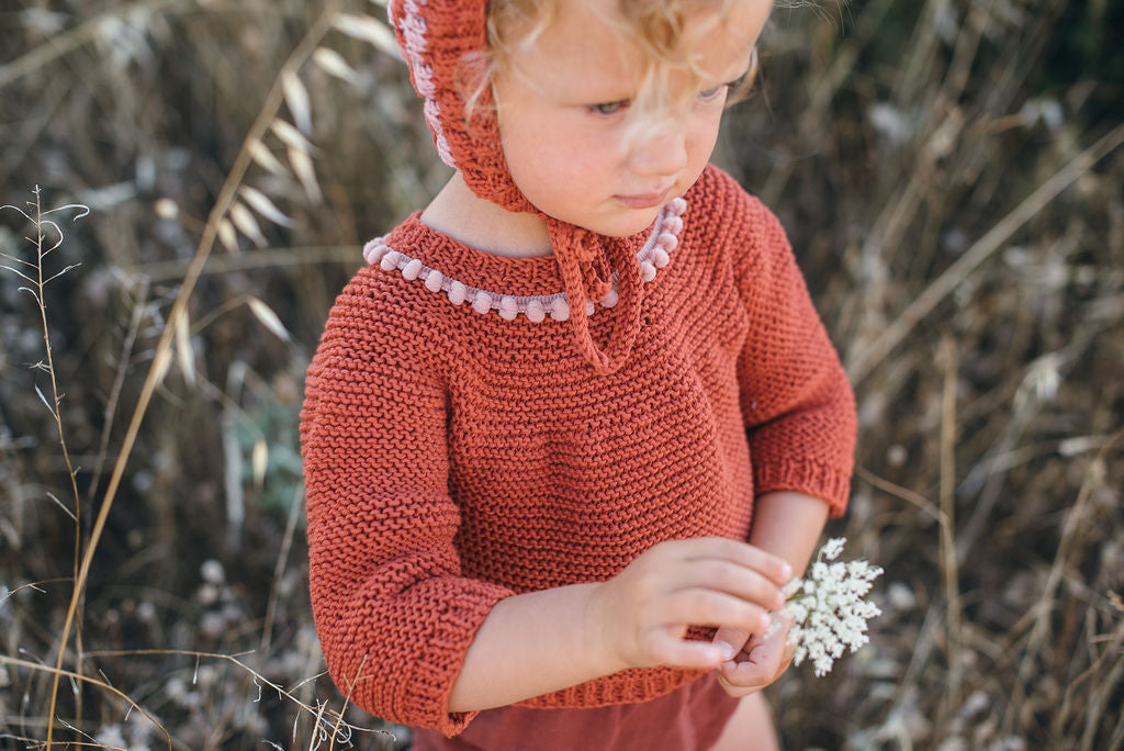 Niña con jersey y capota tejidas en punto a dos agujas de MöMMOT