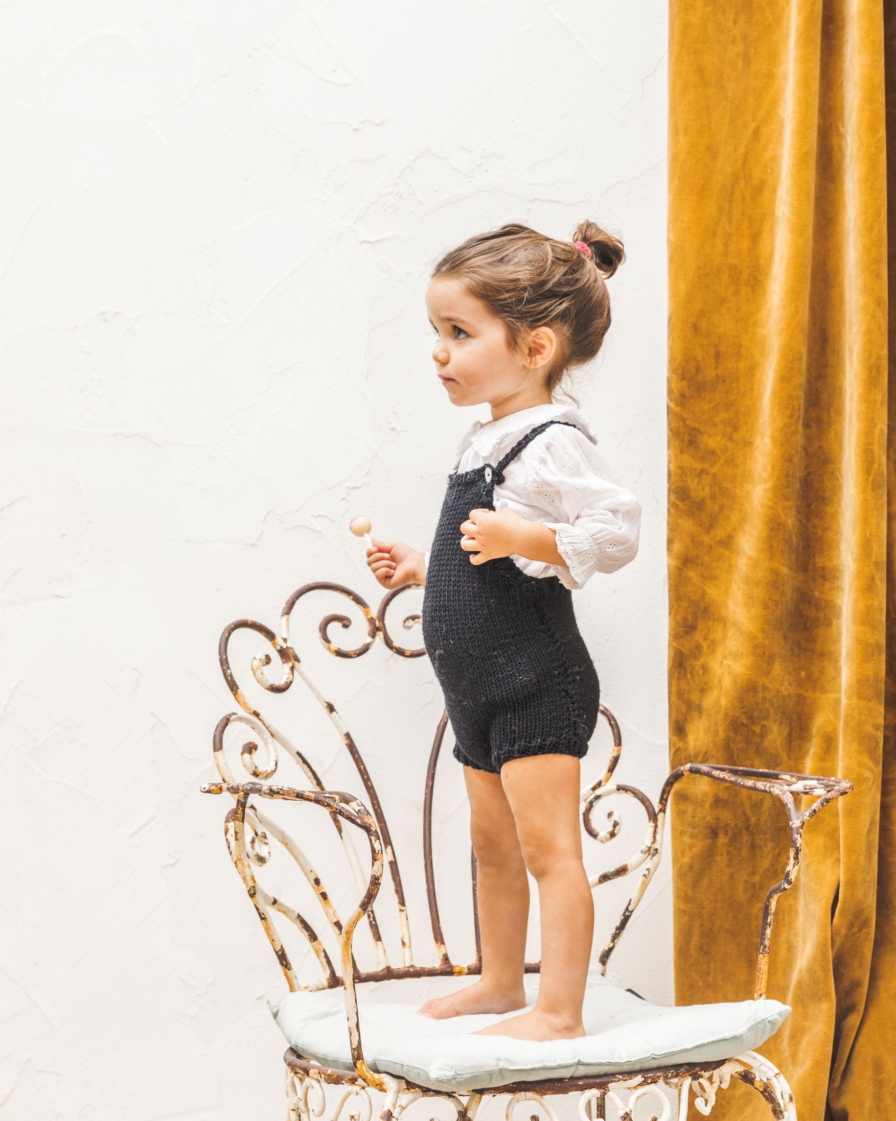 Niña con peto negro tejido en lana negra de MöMMOT