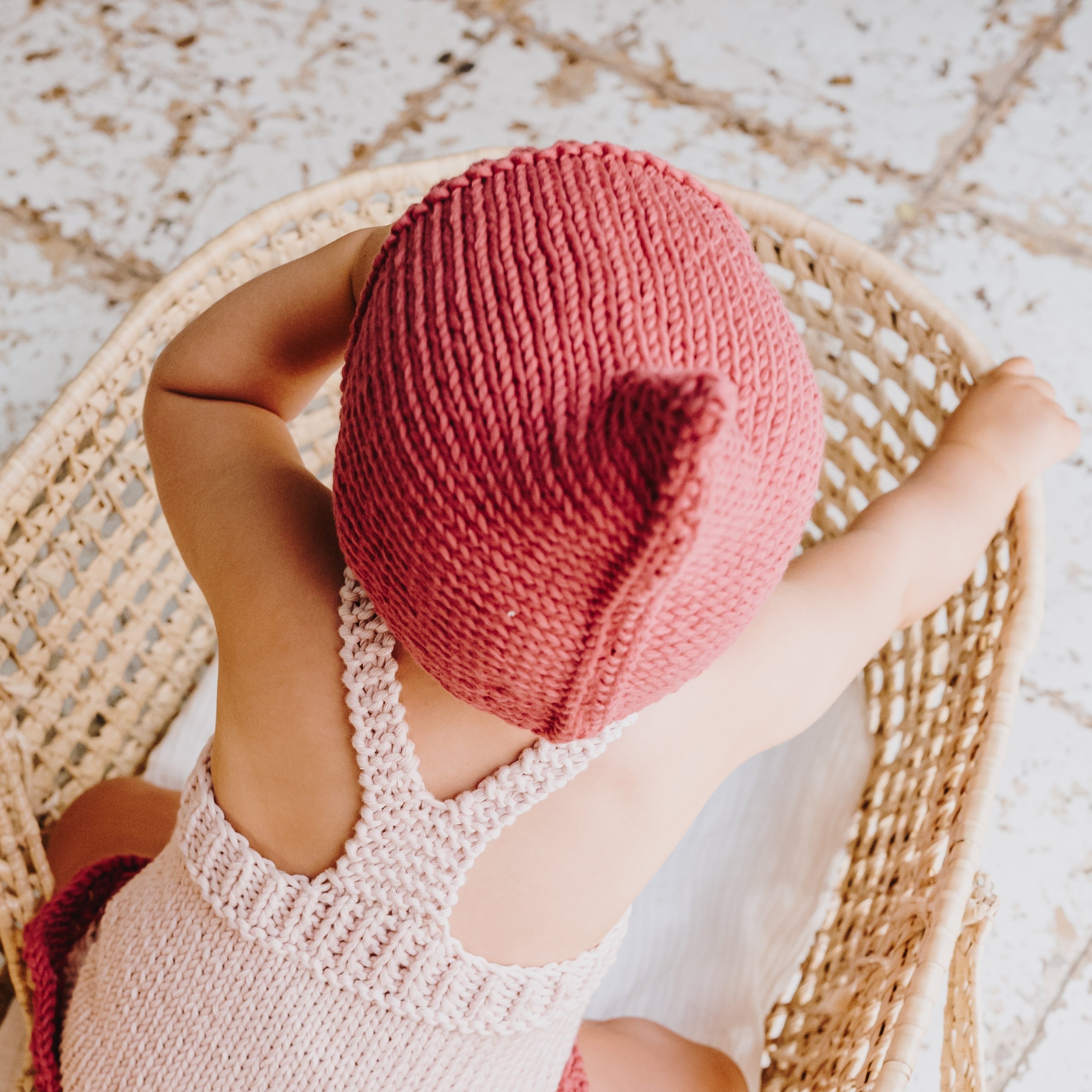 Capota tejida en punto a dos agujas en algodón orgánico color fresa de MöMMOT
