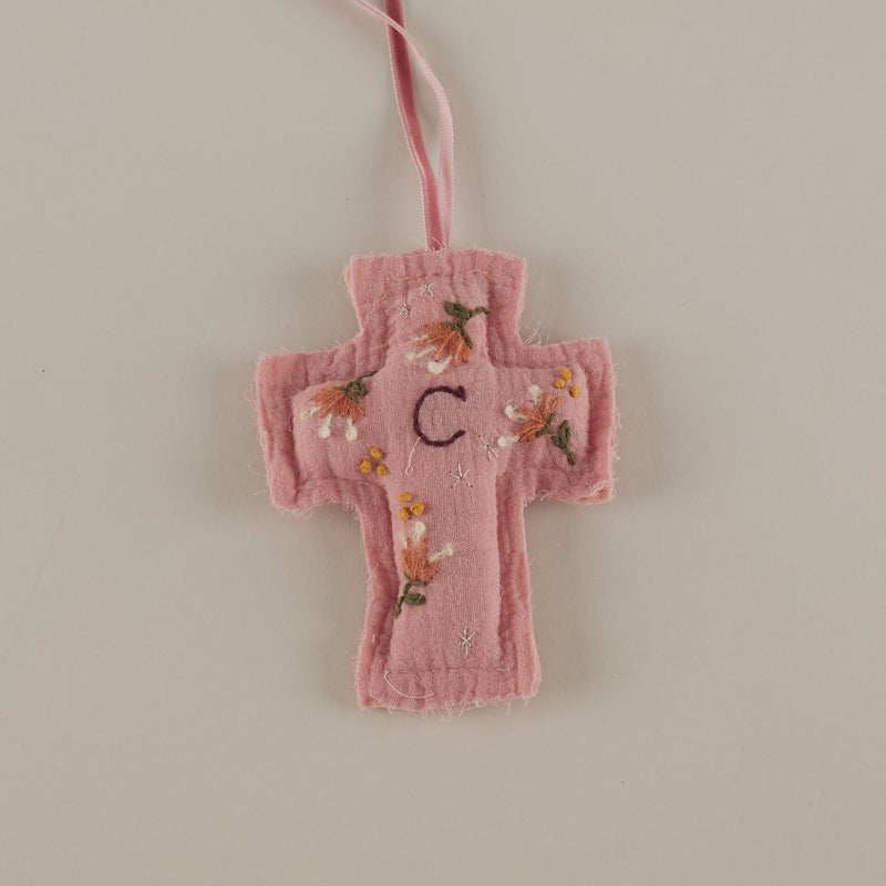 Cruz rosa bordada a mano con inicial para cuna
