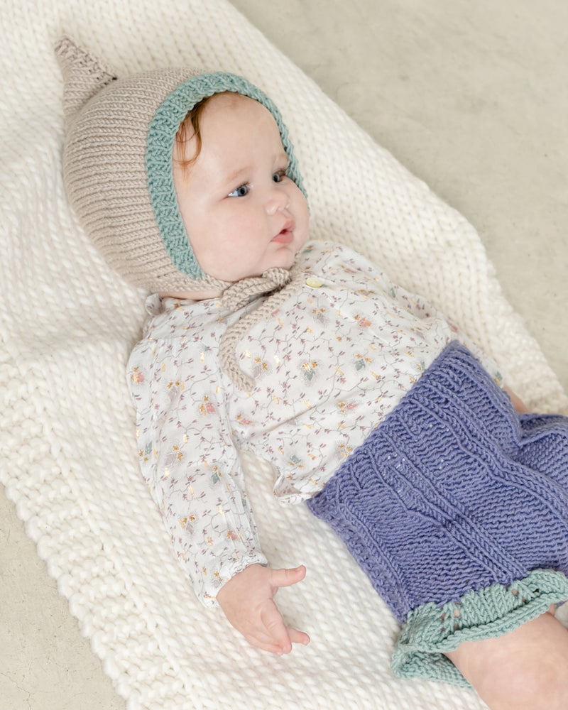Bebé con capota gnomo y braguita tejidas a mano con patrón de MöMMOT