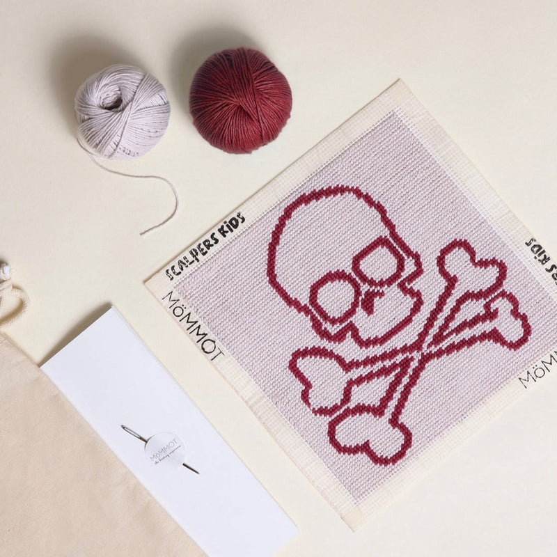 Kit de Petit Point de MöMMOT en colaboración con Scalpers para bordar la mítica calavera en color berenjena y fondo hueso